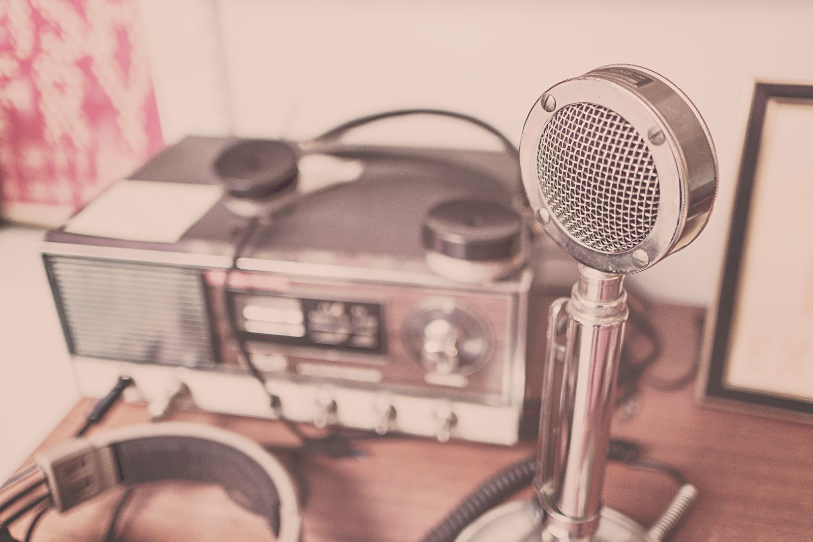 A podcast microphone on a stand in a small recording booth